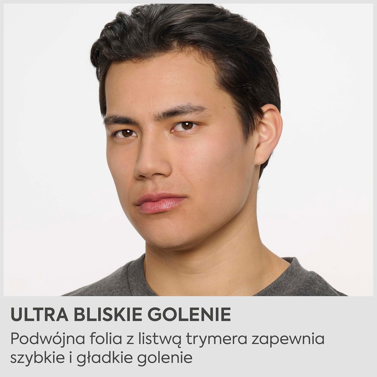 Portret mężczyzny z ciemnymi włosami w szarym t-shircie, z tekstem na dole.