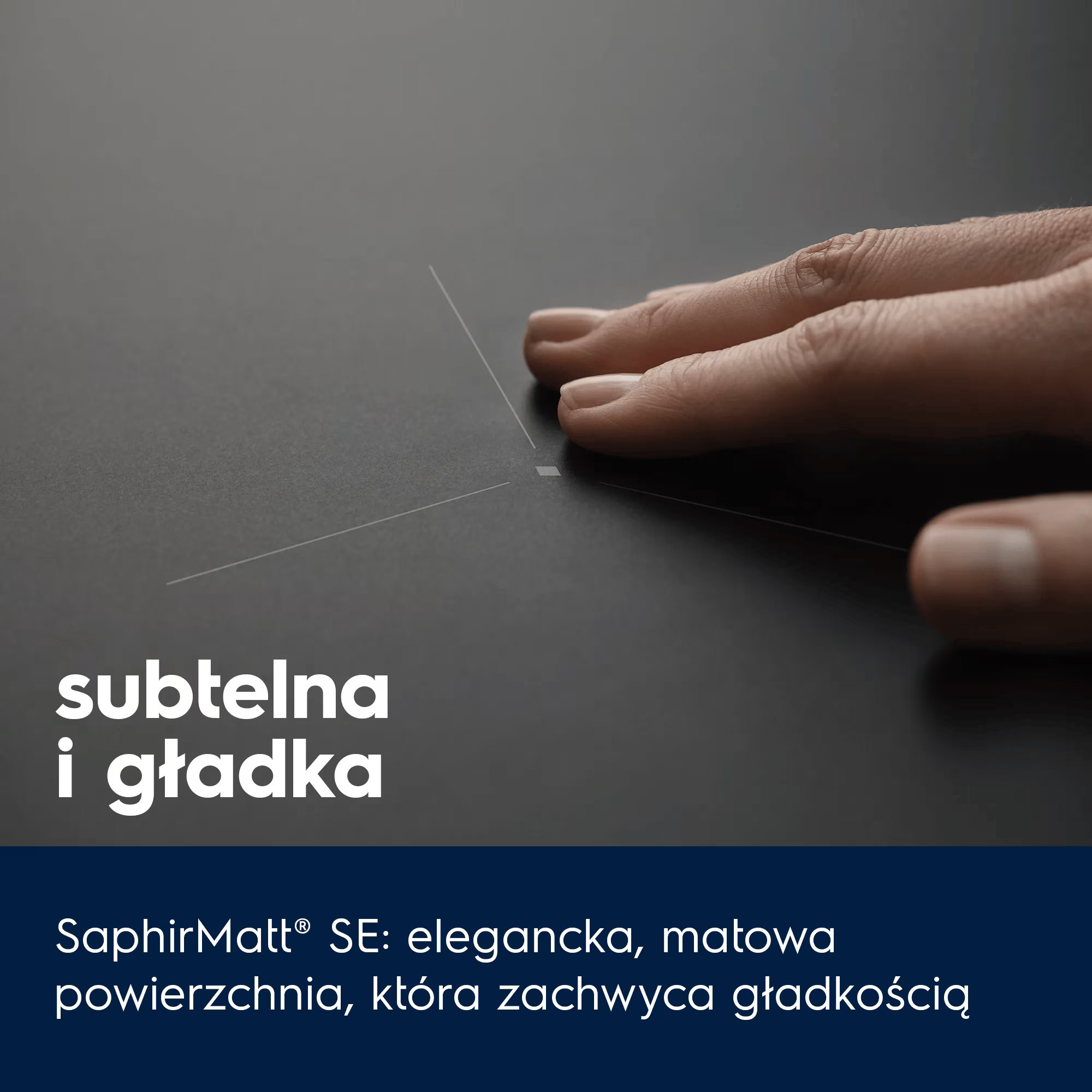 Dłoń dotyka matowej, czarnej płyty grzewczej z delikatnymi liniami.