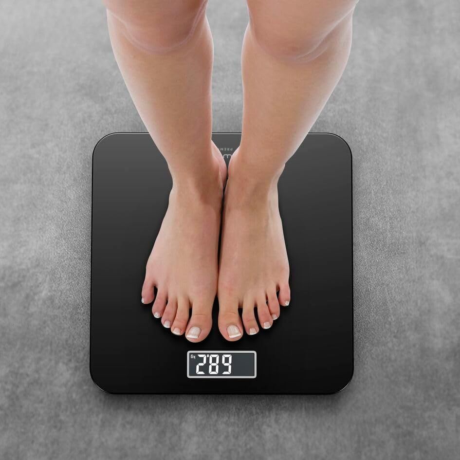 Füße auf einer schwarzen Waage, die 68,2 kg anzeigt.