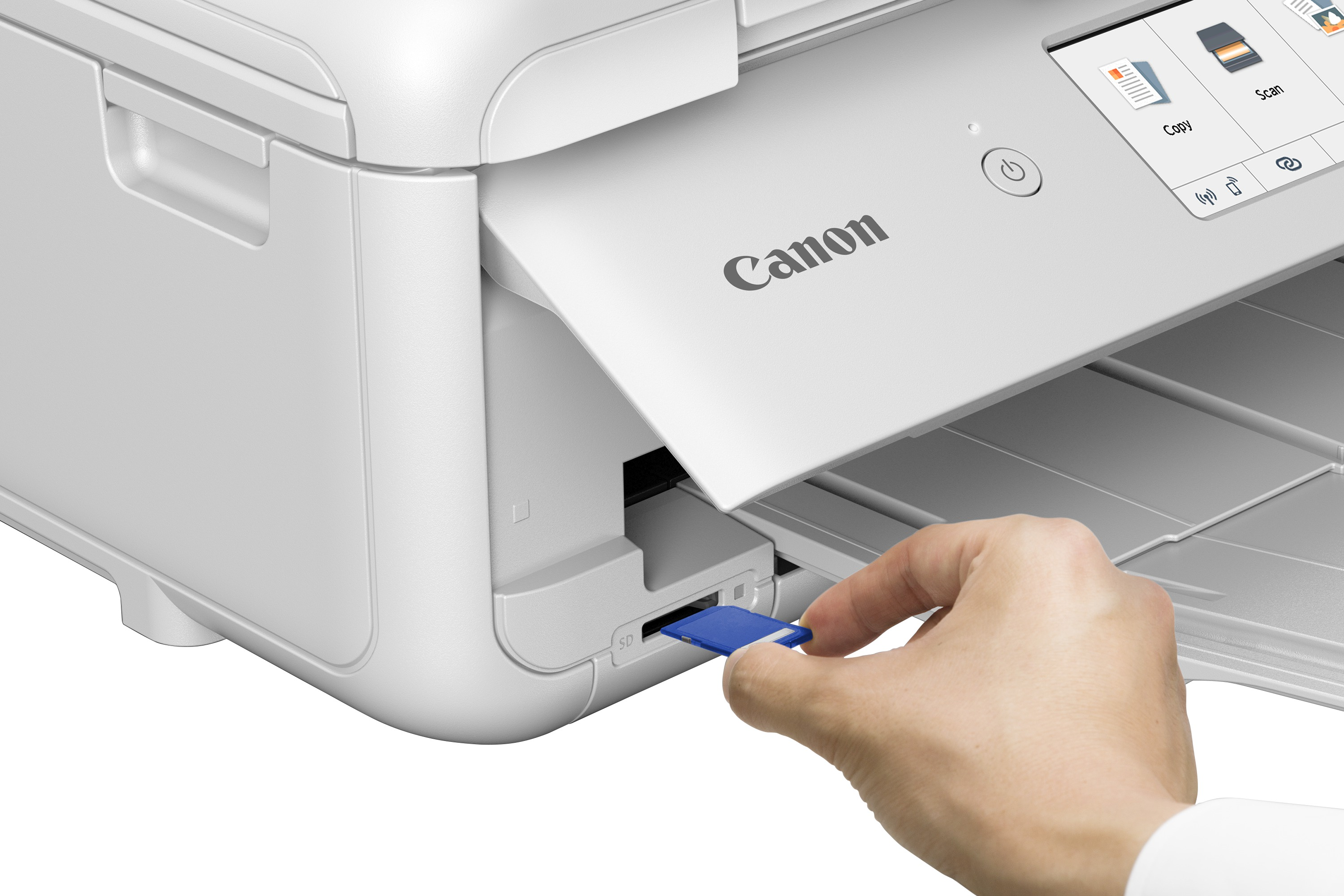 Une main insère une carte SD bleue dans une imprimante Canon blanche.