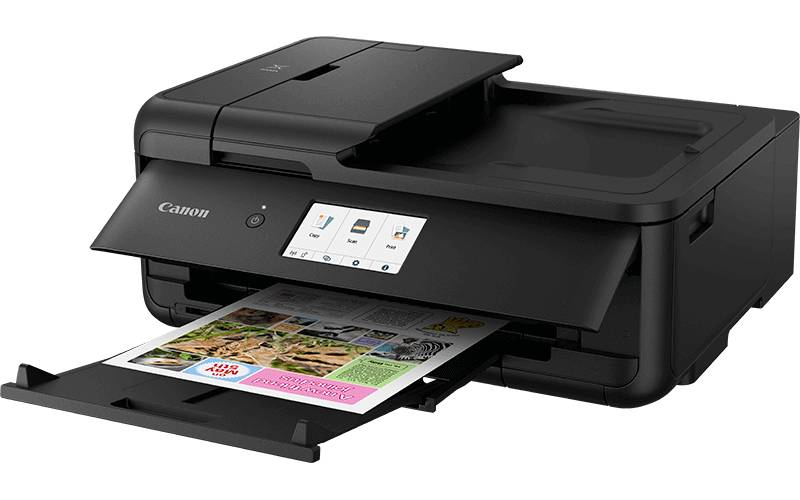 Una stampante multifunzione Canon nera con un foglio di carta che esce dal vassoio inferiore.
