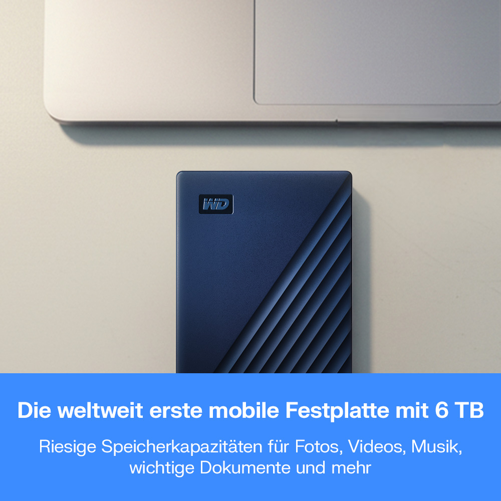 Blaue WD Festplatte neben einem Laptop, mit deutschem Text.