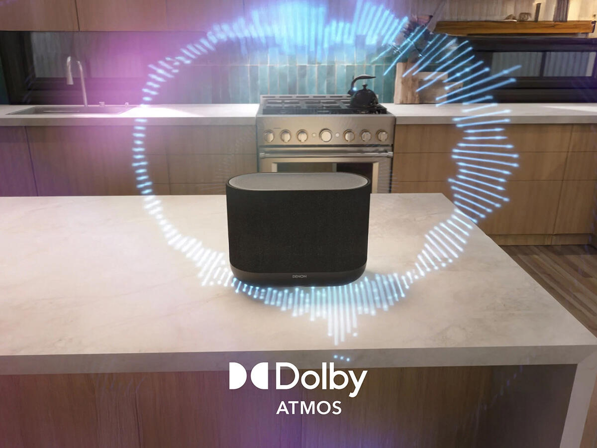 Fekete Denon hangszóró konyhapulton Dolby Atmos logóval és hanghullám grafikával.