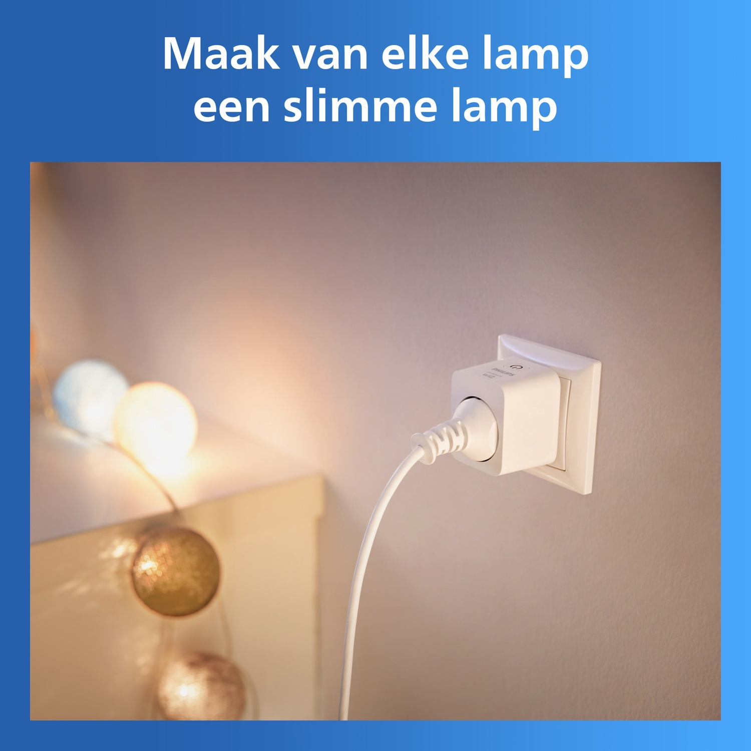 A white plug is inserted into a wall socket. String lights in the background.