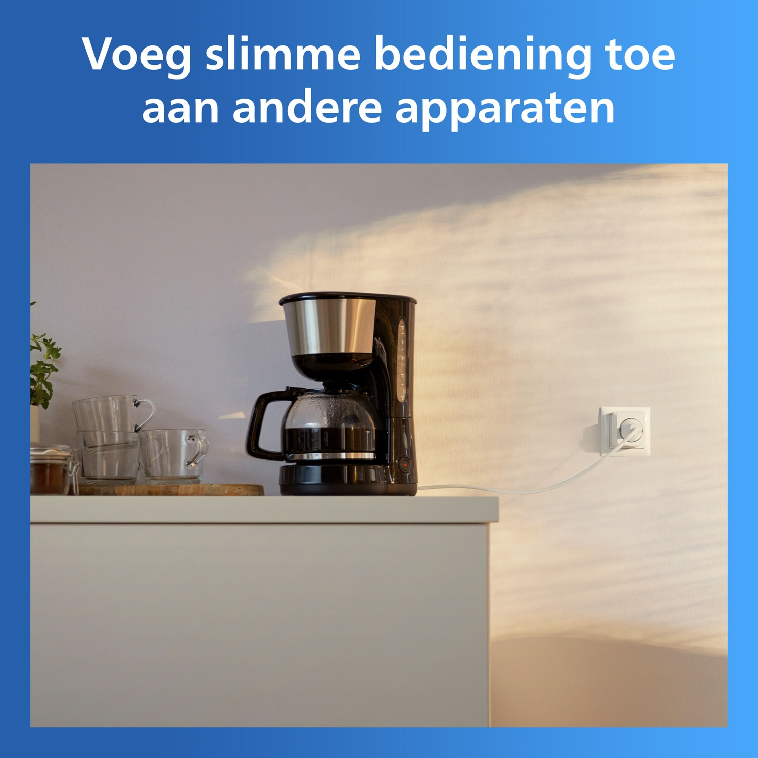 A coffee maker sits on a white cabinet, next to glasses and a plug in the wall.
