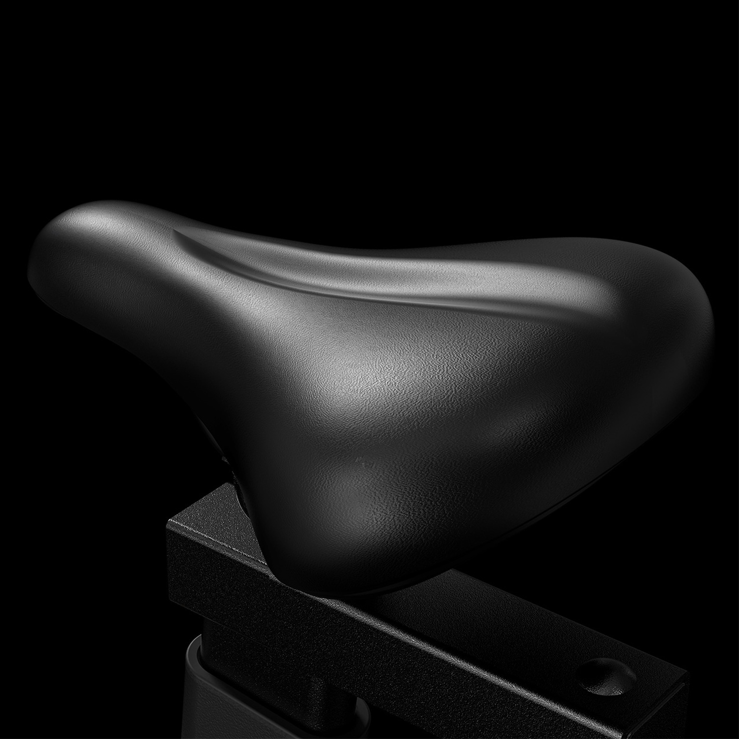 Una sella da bicicletta nera su sfondo nero, focalizzata sulla sua texture.