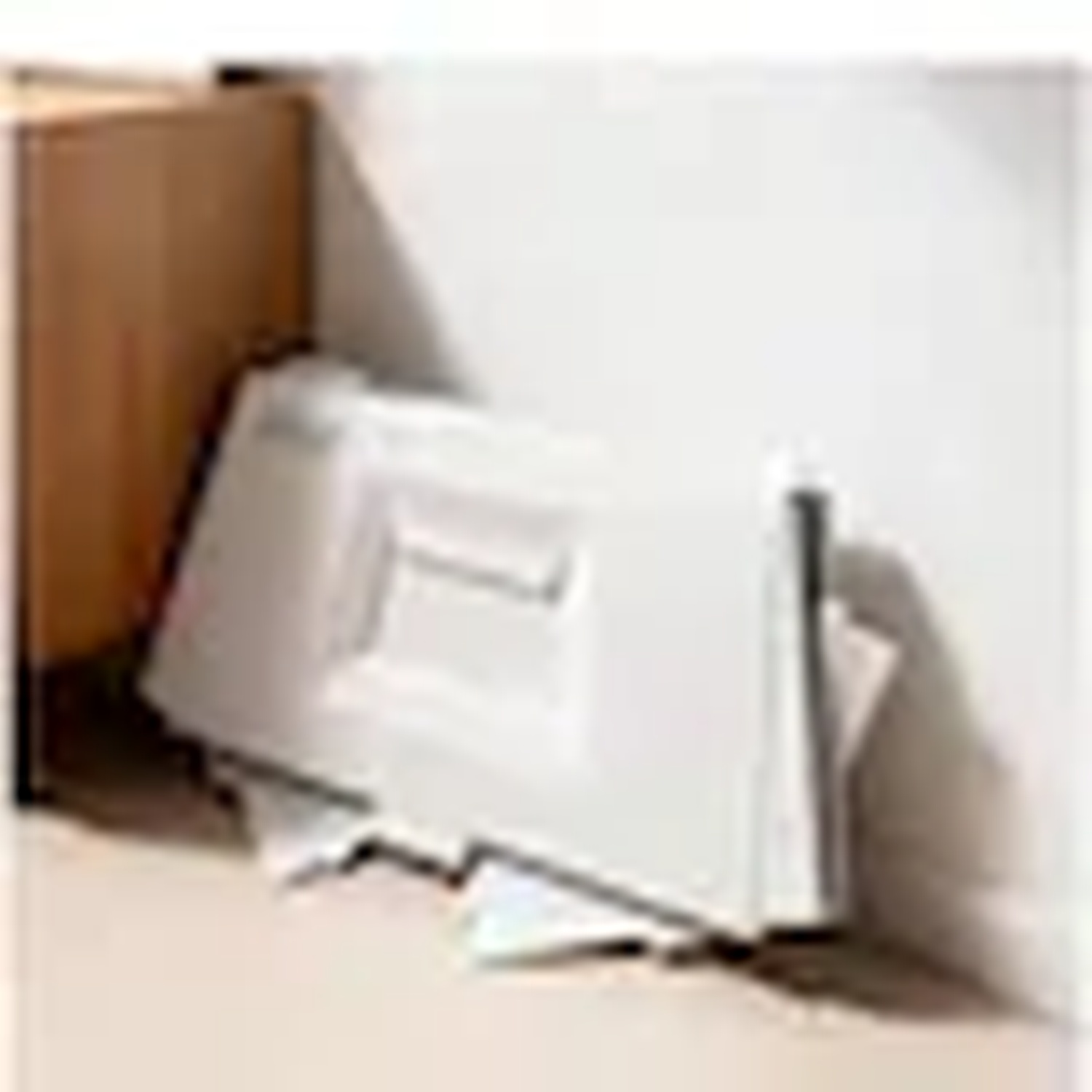 A white cabinet door lies on the floor next to a wooden box.