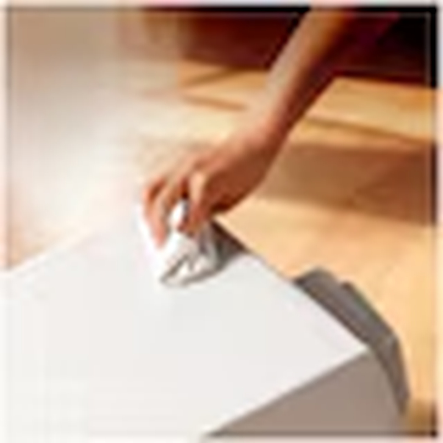 A hand wipes a white device with a white cloth.