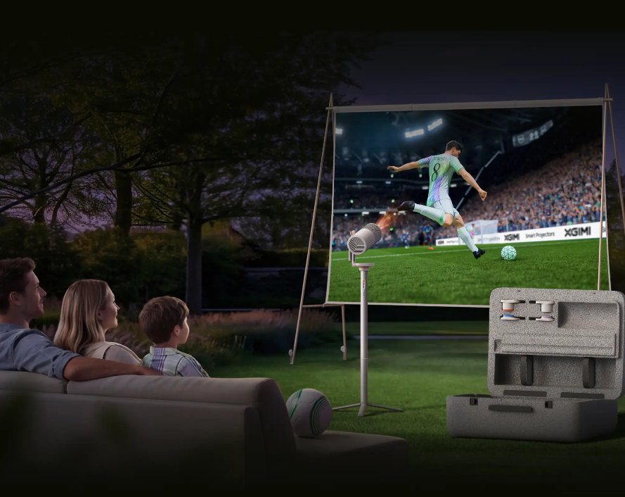 Eine Familie schaut abends draußen Fußball auf einem Projektor.