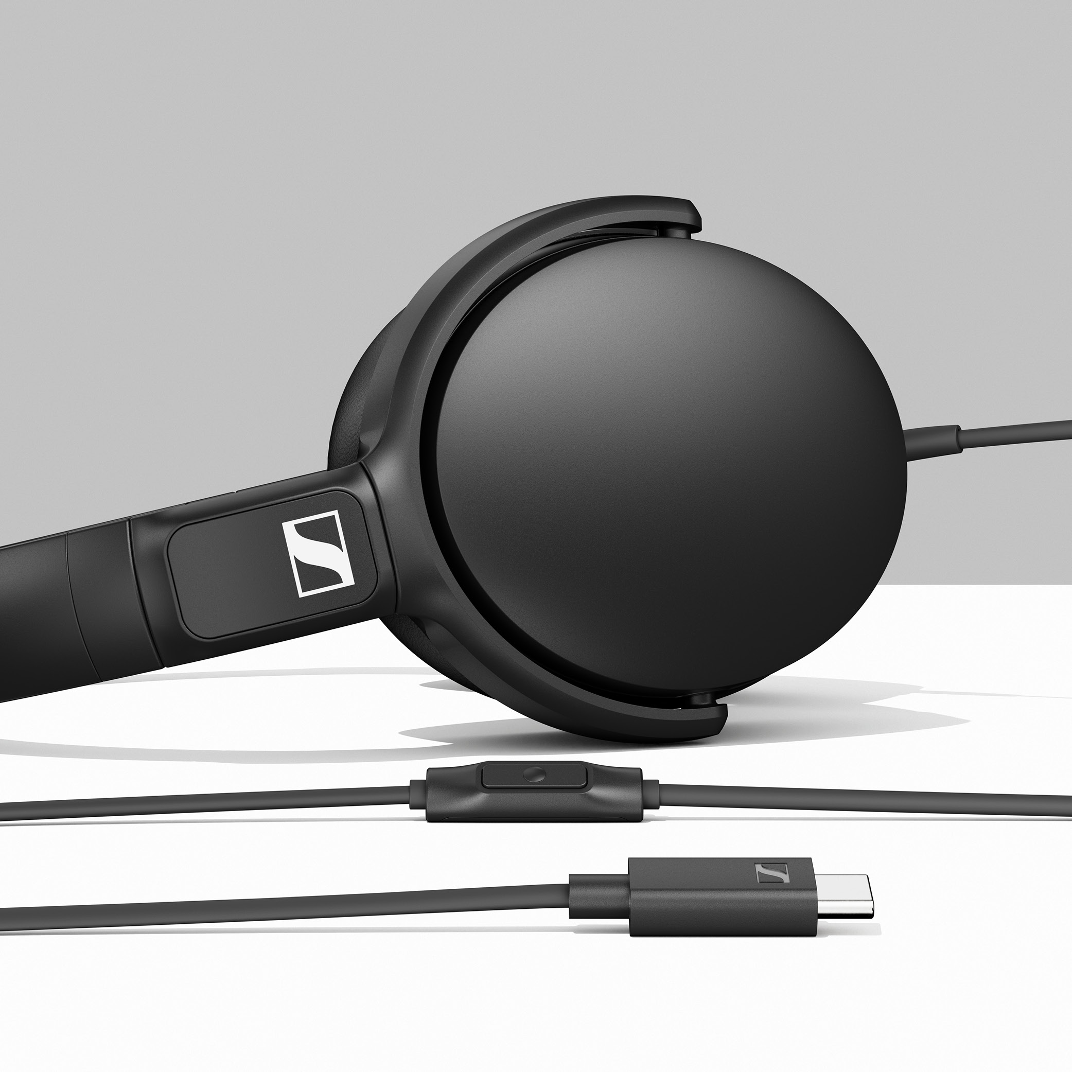 Beyaz logolu ve USB-C konektörlü siyah kulaklık.