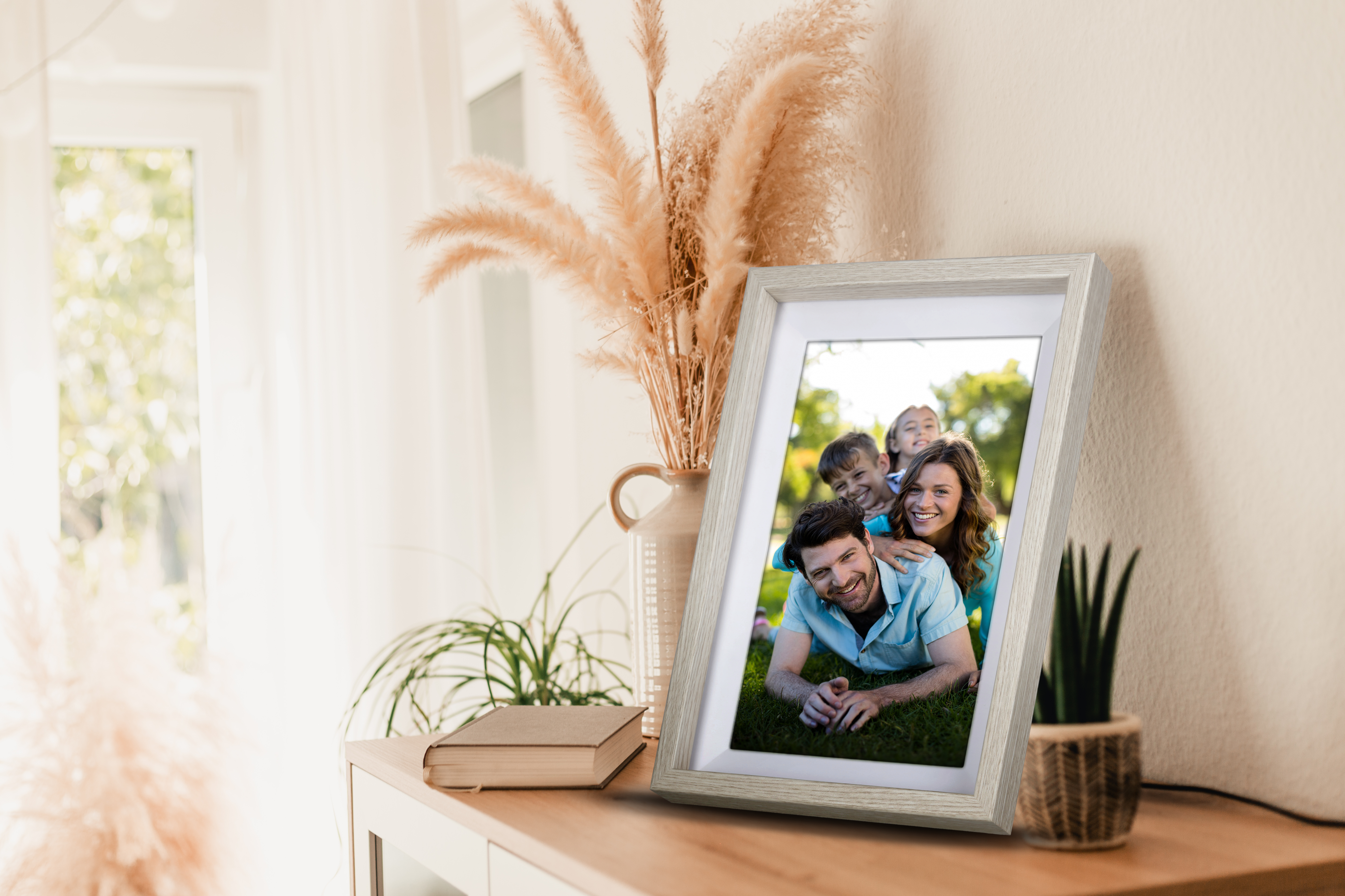 Gerahmtes Foto einer lachenden Familie im Freien auf einer Wiese.