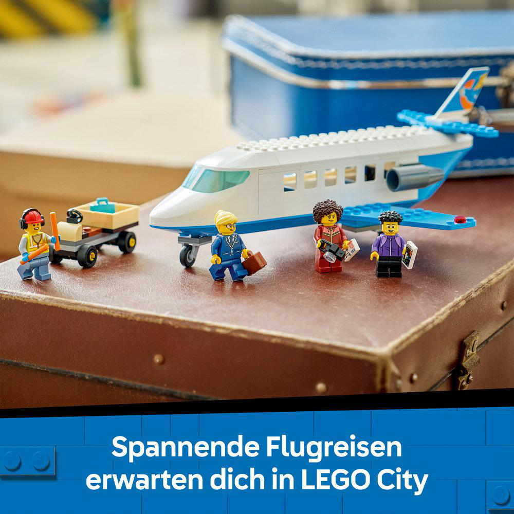 LEGO City Flugzeug mit Figuren und Gepäckwagen auf alten Koffern.
