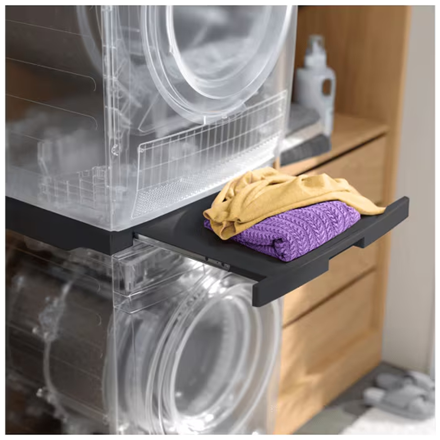 A yellow and a purple garment lie on a black shelf.