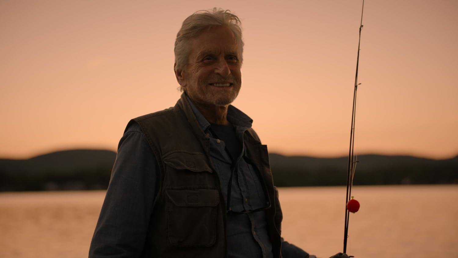 Ein älterer Mann mit grauem Haar angelt bei Sonnenuntergang auf einem See.