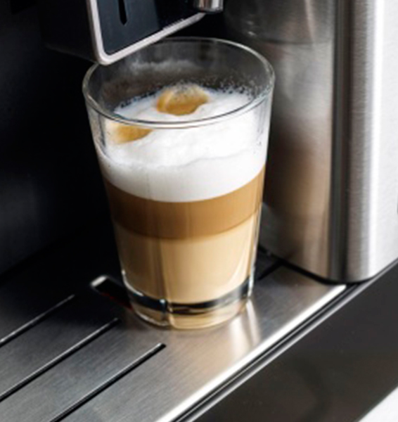 Szklanka latte macchiato z pianką mleczną na ekspresie do kawy.