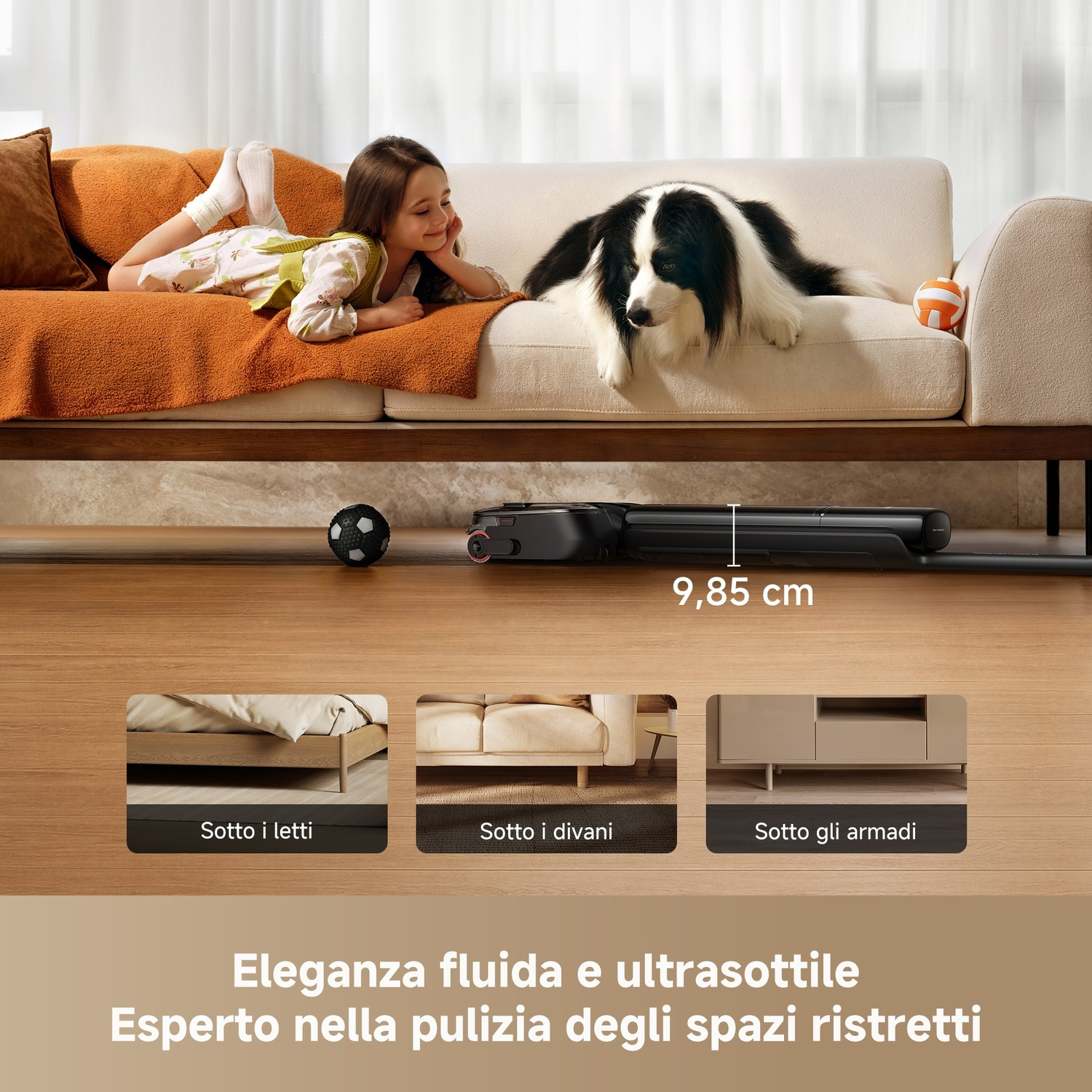 Un cane e una bambina sono sul divano. Un robot aspirapolvere è sotto.