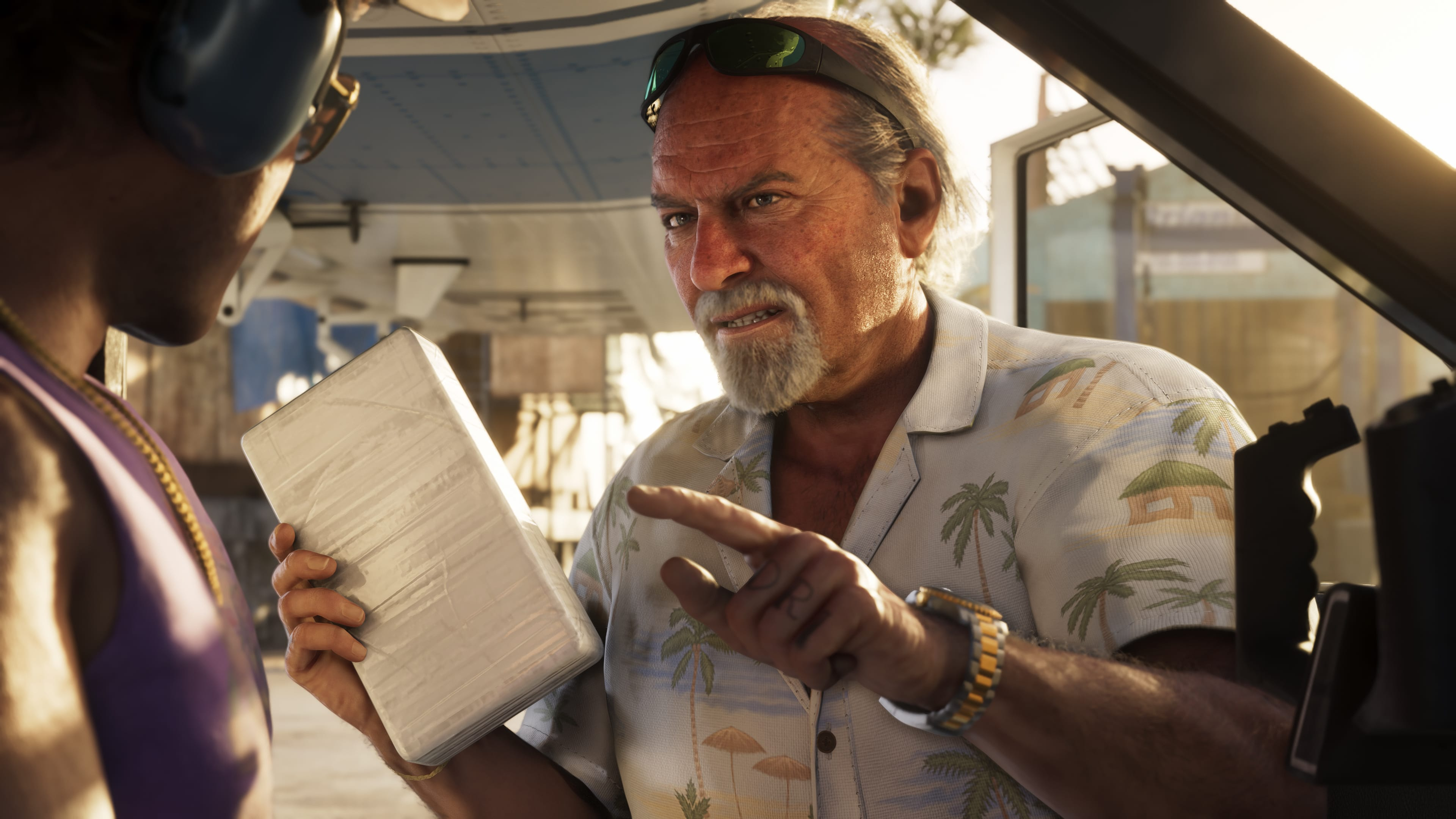 Hombre con camisa hawaiana muestra un gran paquete blanco a persona con auriculares.