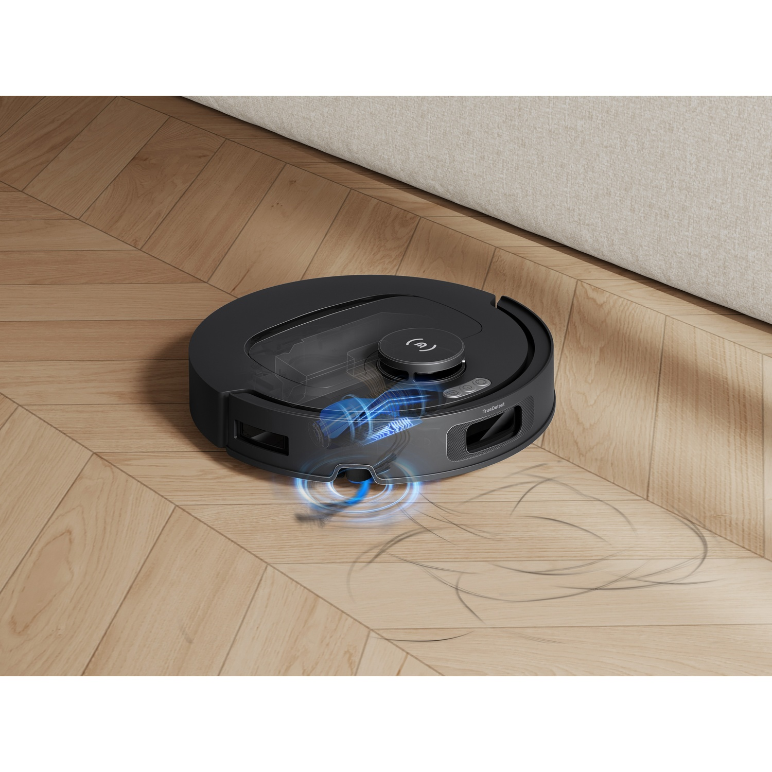 Un robot aspirapolvere nero pulisce un pavimento in legno.