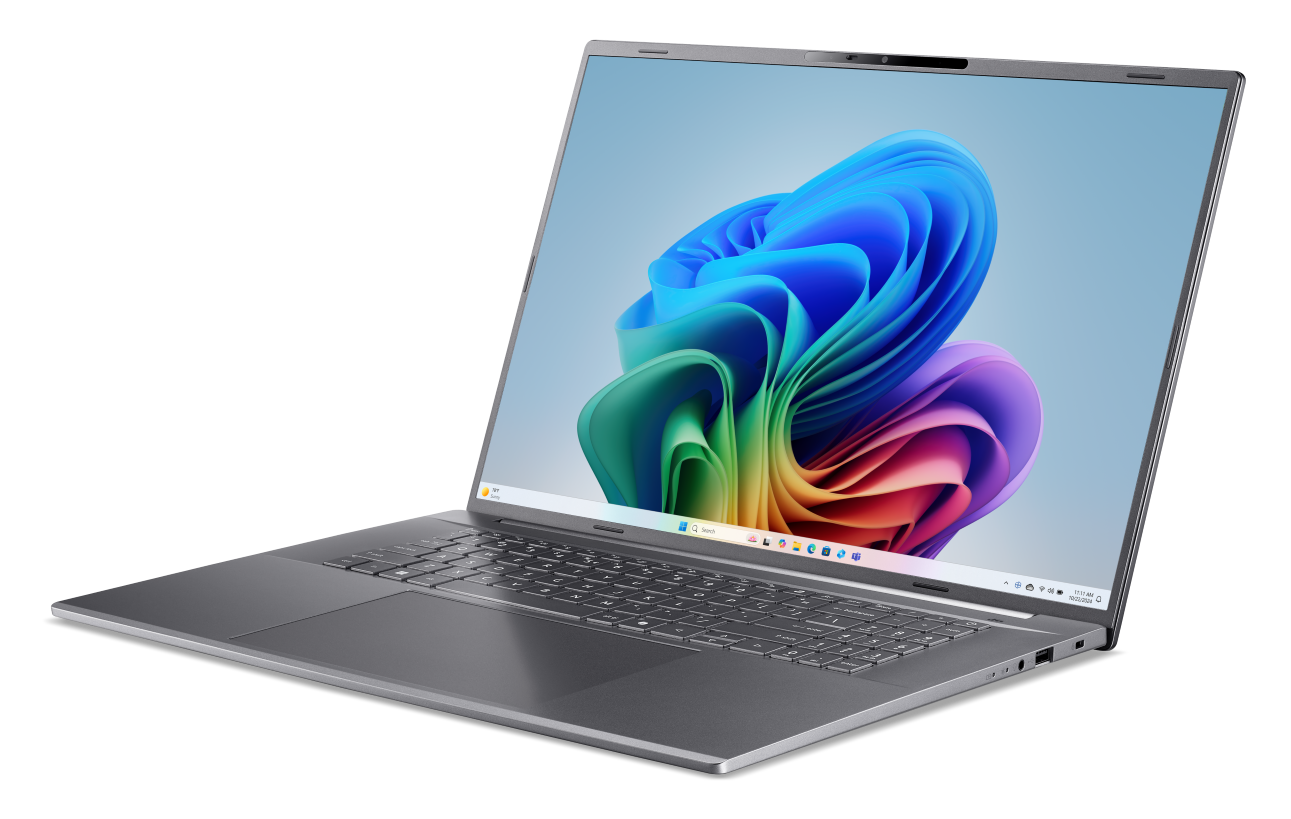 Otwarty szary laptop z kolorową tapetą Windows i klawiaturą.