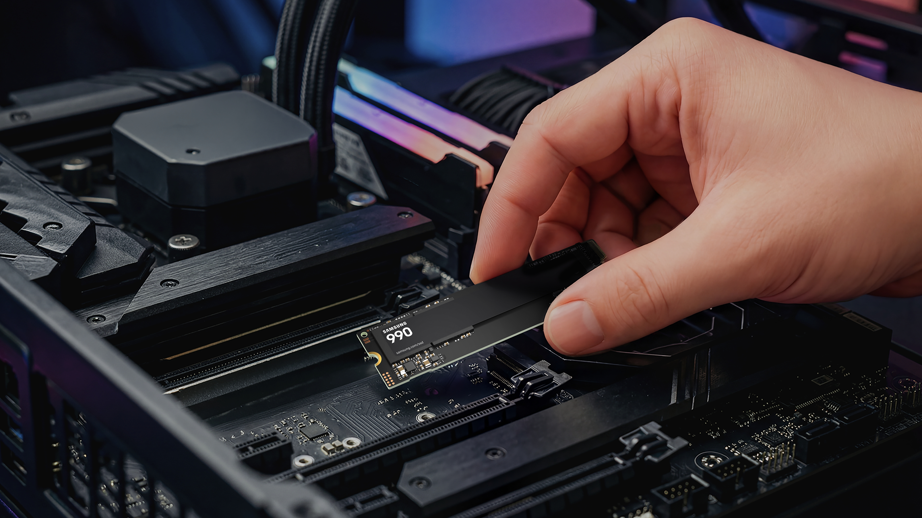 Eine Hand setzt eine Samsung 990 SSD in einen PC-Motherboard-Steckplatz ein.