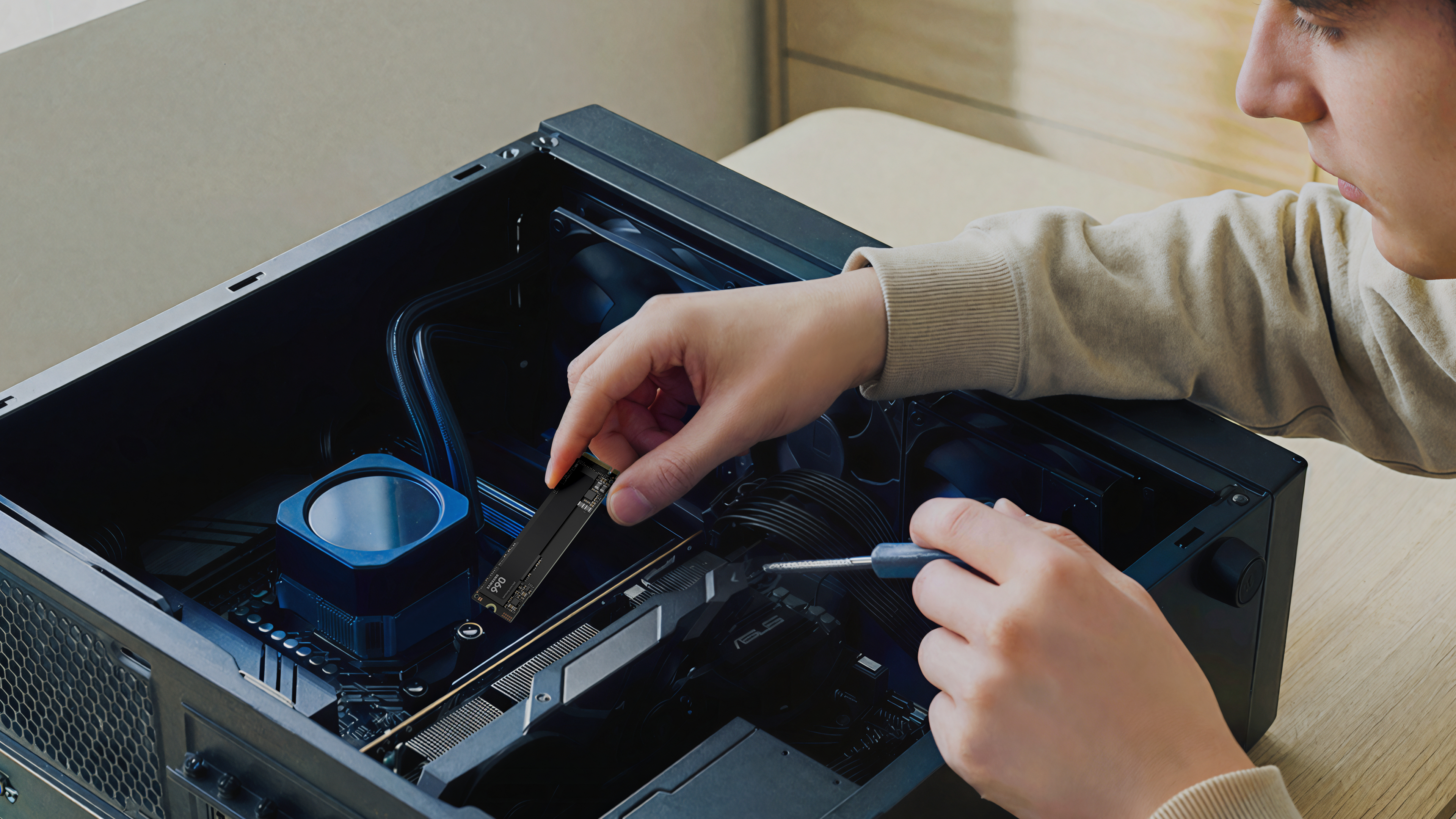 Ein Mann installiert eine SSD in einen Computer. Blaue Kühlerlüfter sind sichtbar.