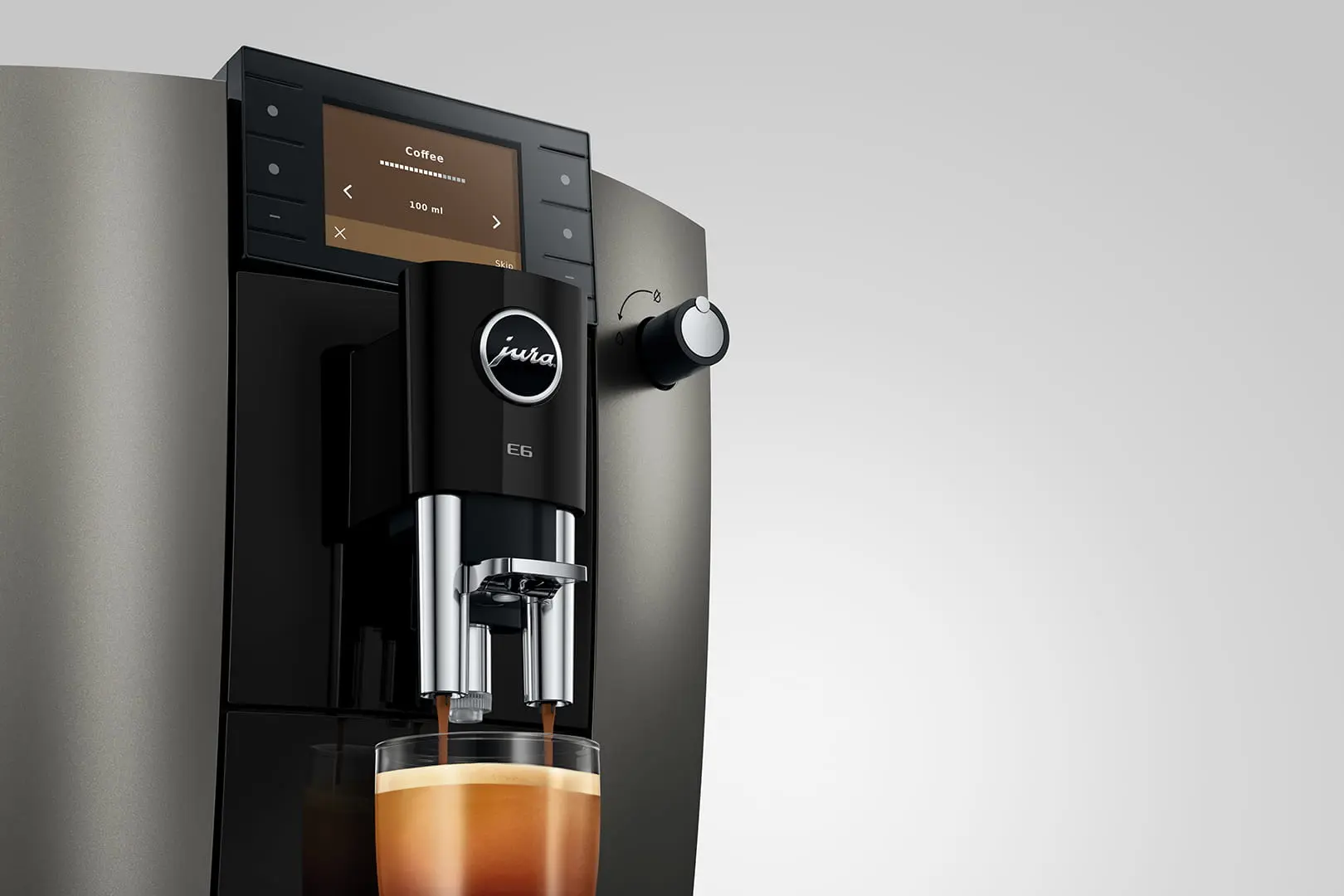 Una macchina da caffè nera prepara caffè in un bicchiere, il display mostra Caffè 100 ml.