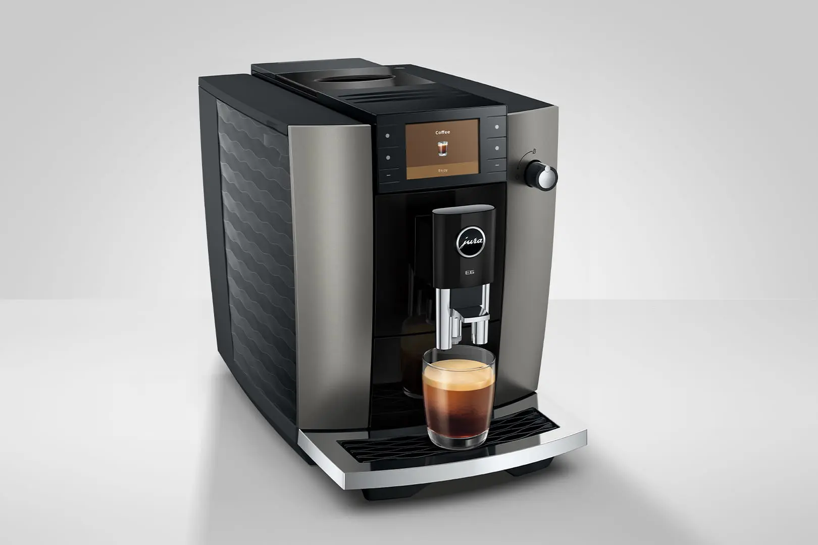 Una moderna macchina da caffè con un bicchiere di espresso sul vassoio raccogligocce.
