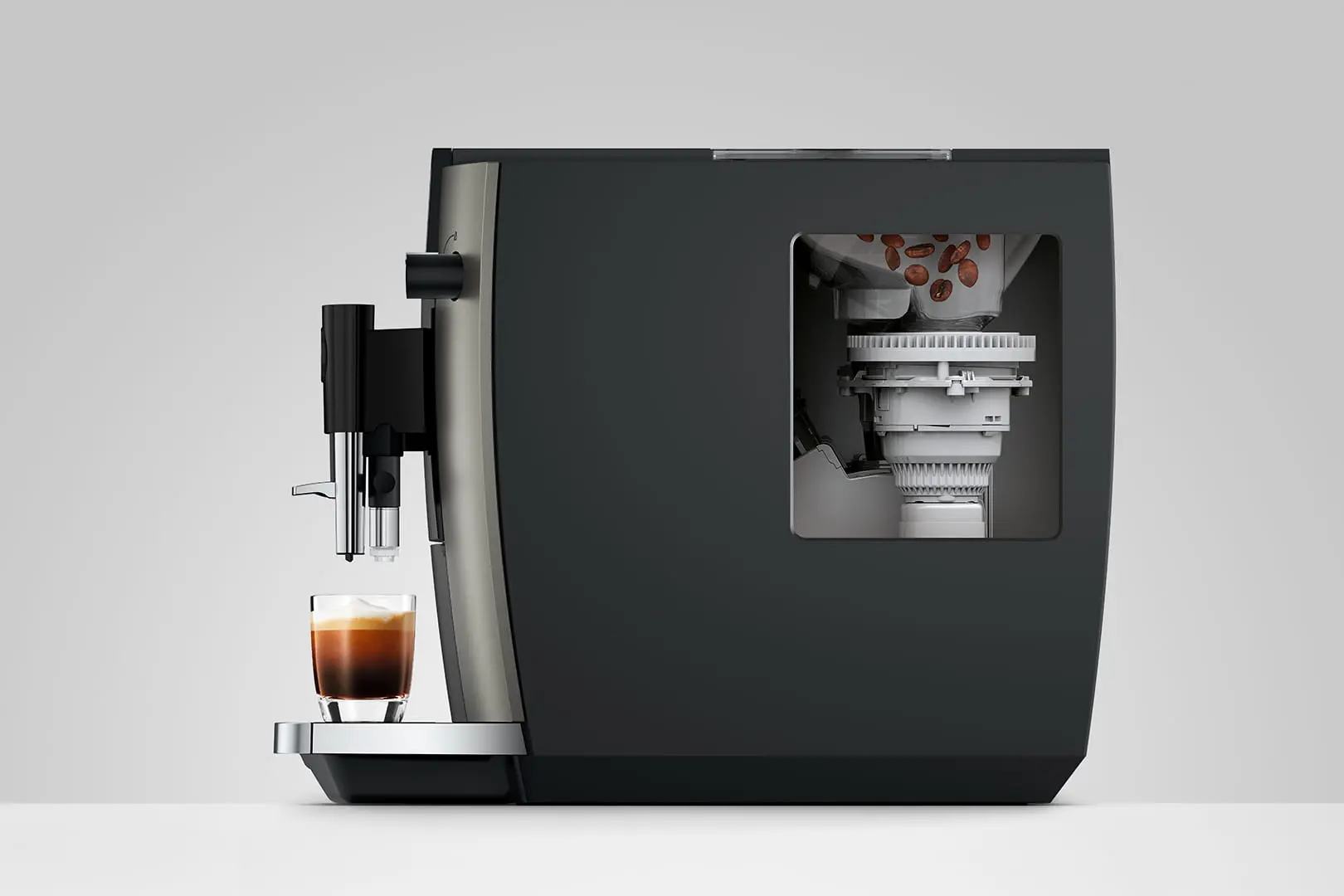 Una macchina da caffè con un bicchiere di espresso e chicchi di caffè visibili all'interno.