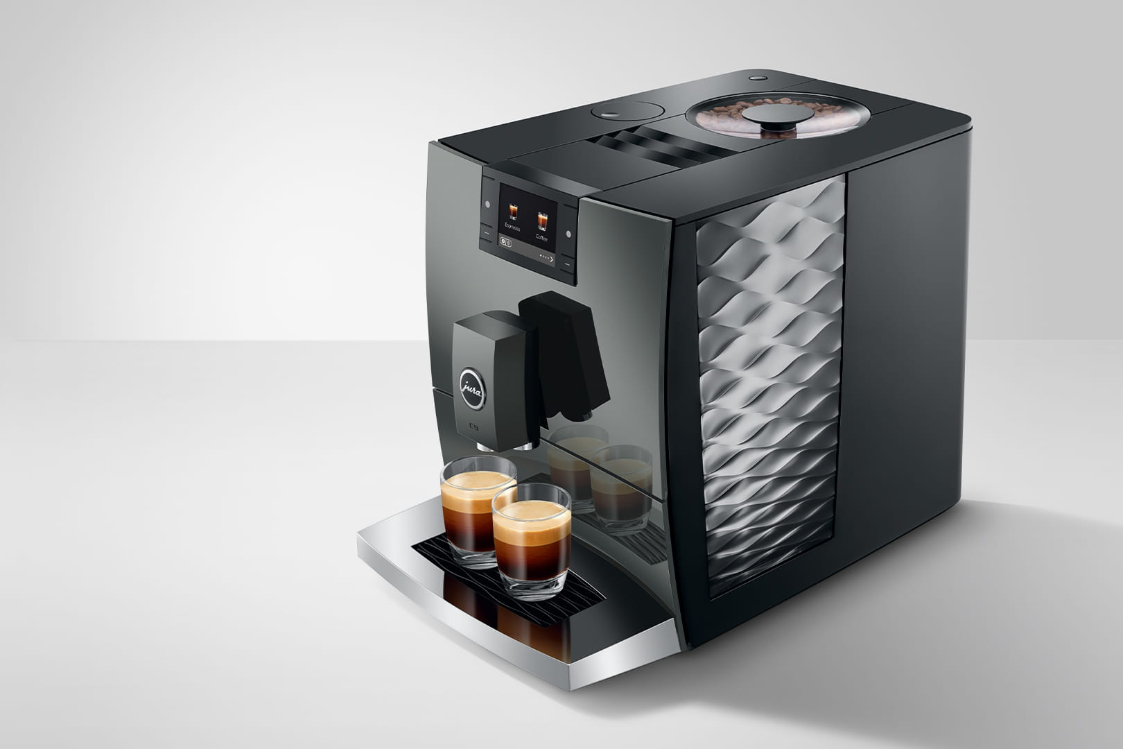 Una macchina da caffè nera con due bicchieri da espresso sulla vaschetta raccogligocce.