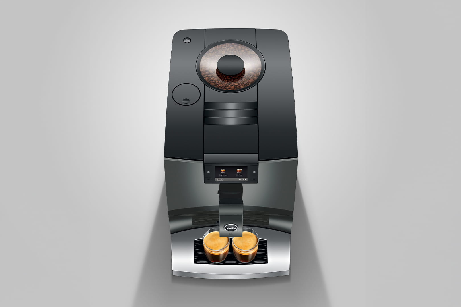 Una macchina da caffè nera con contenitore per chicchi e due tazzine da espresso.