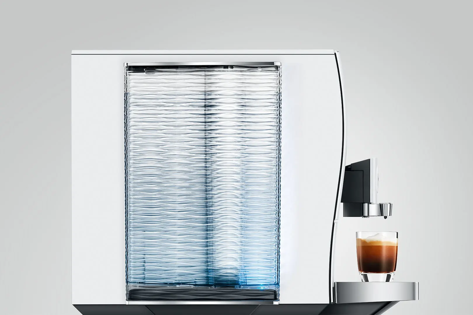 Una macchina da caffè bianca con un bicchiere di espresso e schiuma.