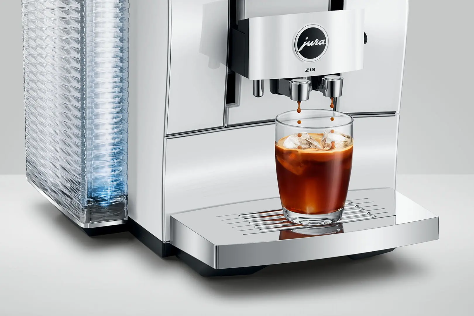 Una macchina da caffè prepara un caffè freddo in un bicchiere con cubetti di ghiaccio.