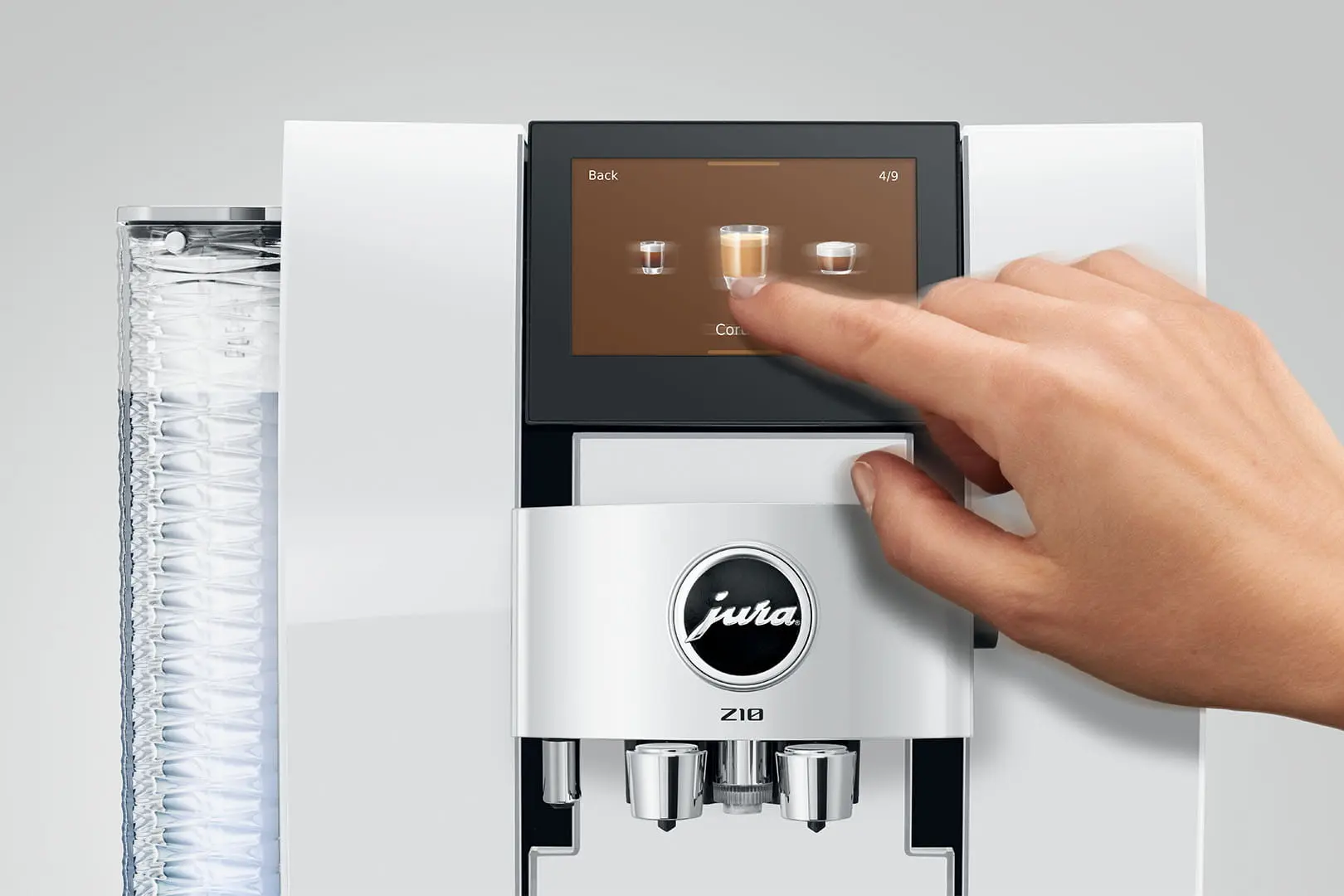 Una mano tocca lo schermo di una macchina da caffè per selezionare un caffè.