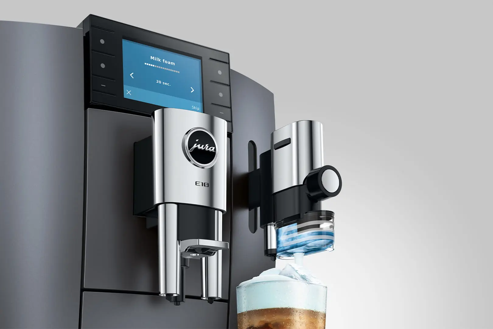 Macchina da caffè con montalatte e bicchiere con ghiaccio e schiuma.