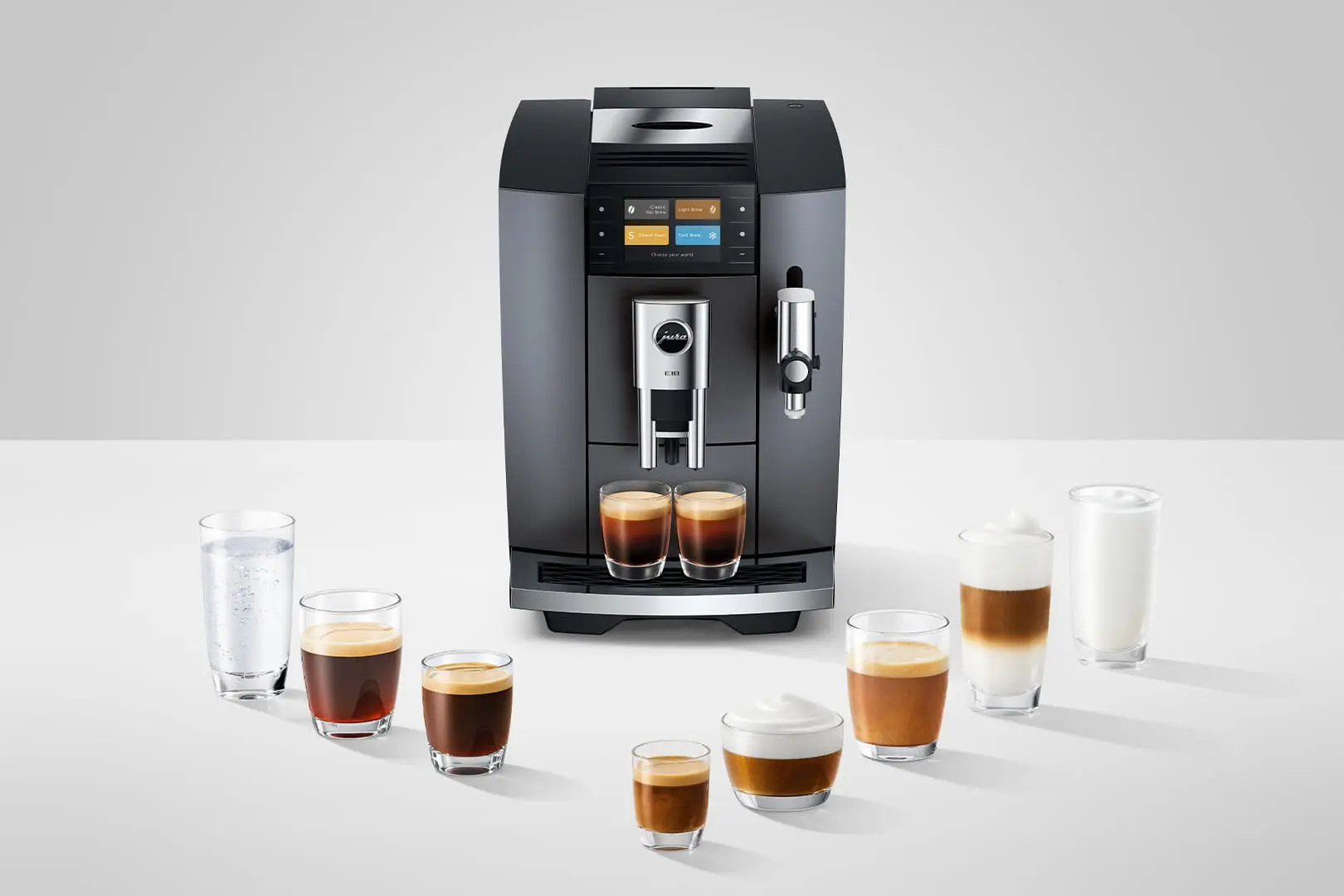 Una macchina da caffè nera è su un tavolo circondata da bicchieri di caffè e latte.