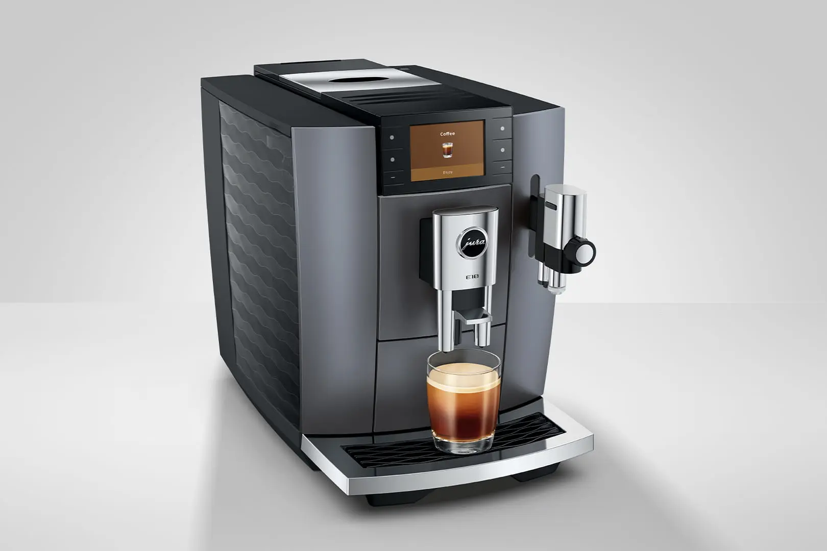 Una macchina da caffè Jura scura con un bicchiere di espresso.
