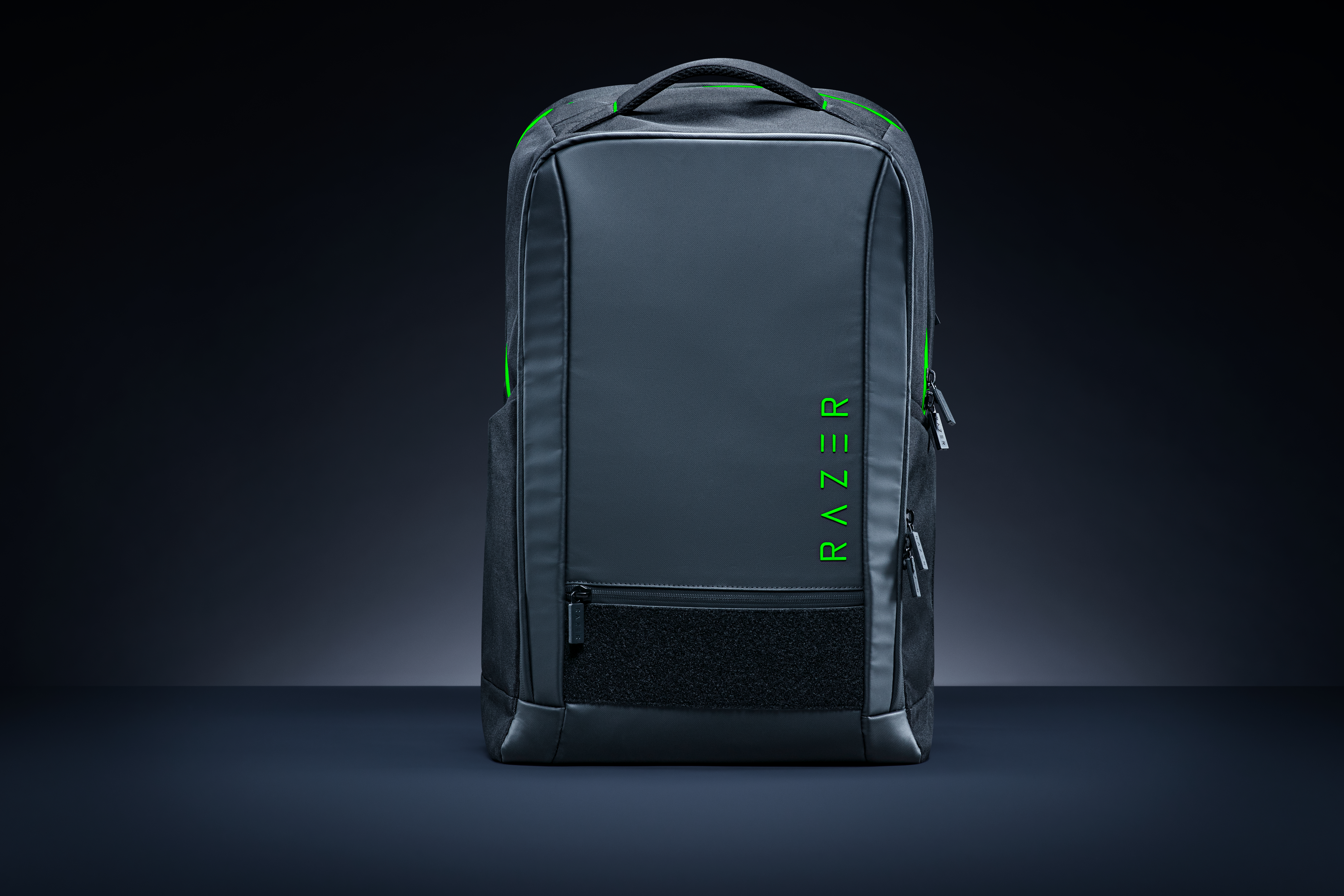 Ein schwarzer Razer-Rucksack mit neongrünen Akzenten steht auf einem dunklen Untergrund.