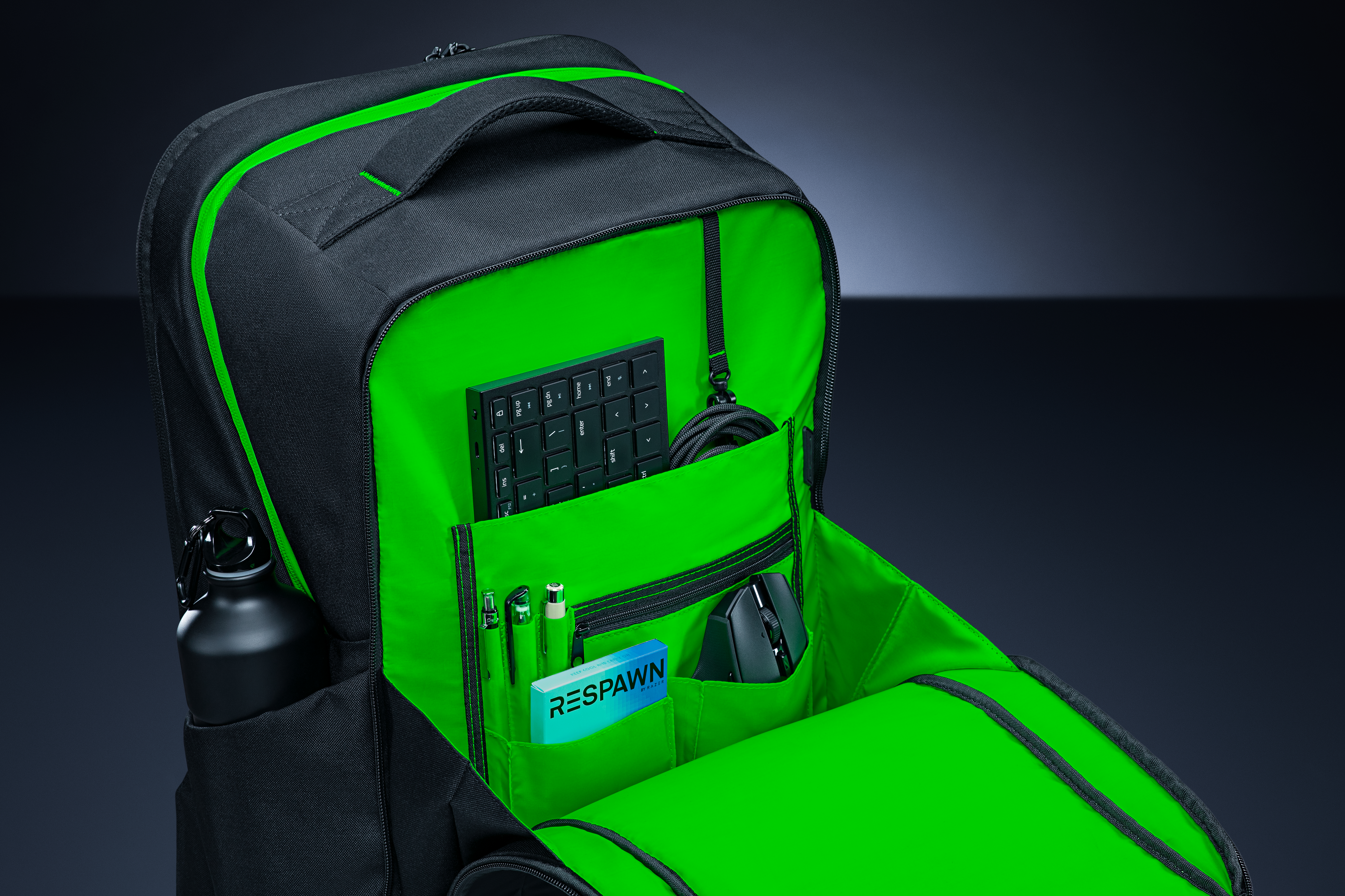 Ein schwarzer Rucksack mit grünen Akzenten, gefüllt mit Gaming-Zubehör.