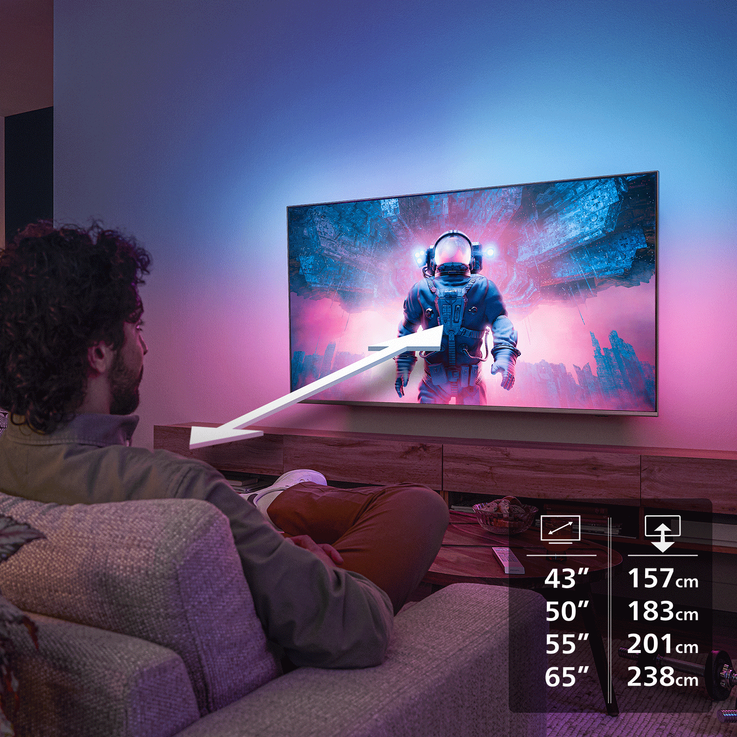Mann sitzt auf Couch und schaut TV mit Astronautenbild, Größenangaben.