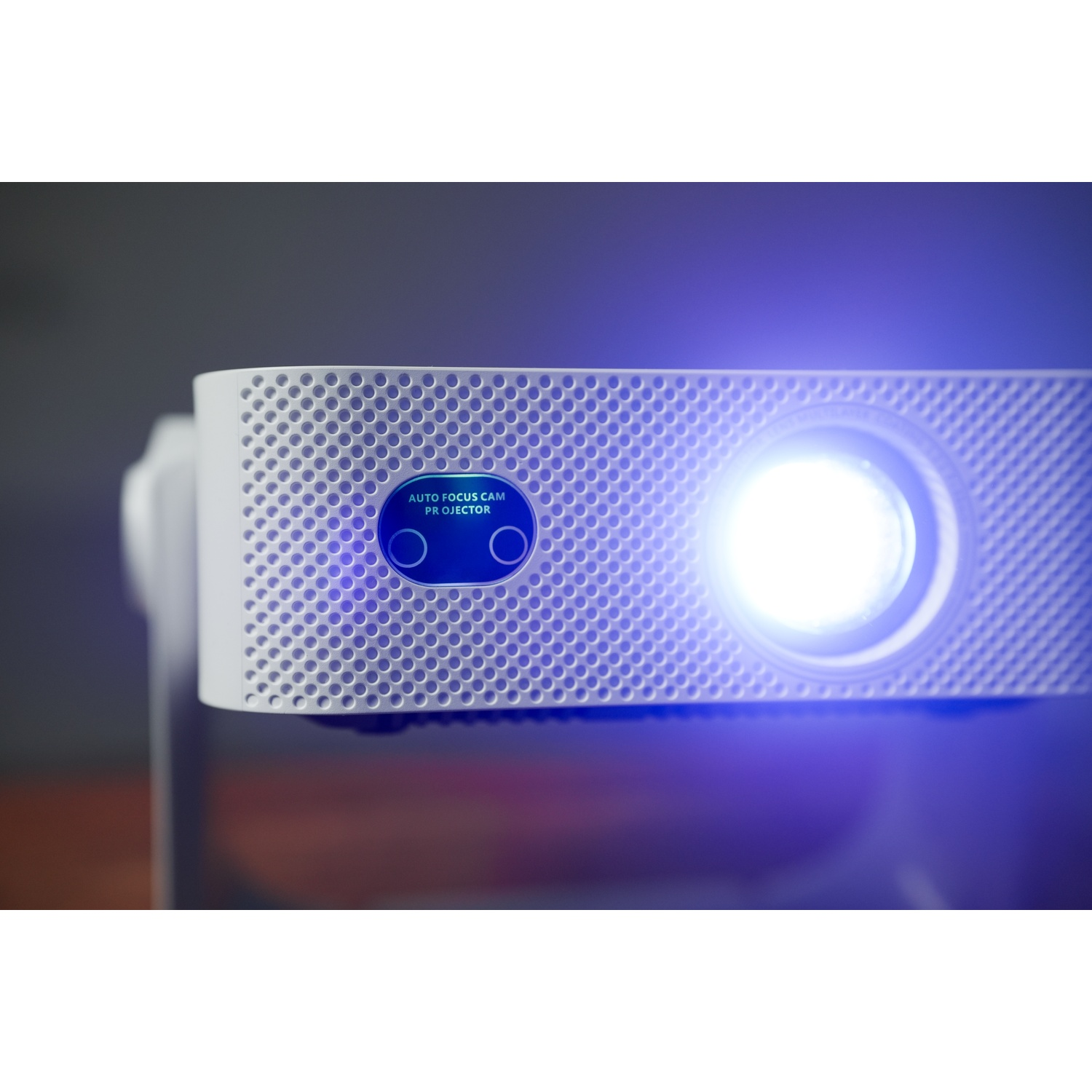 Un proiettore bianco con un fascio di luce blu che emette dalla lente.