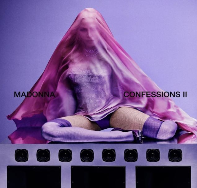 Madonna unter einem lila Tuch auf Lautsprechern sitzend, mit Text.