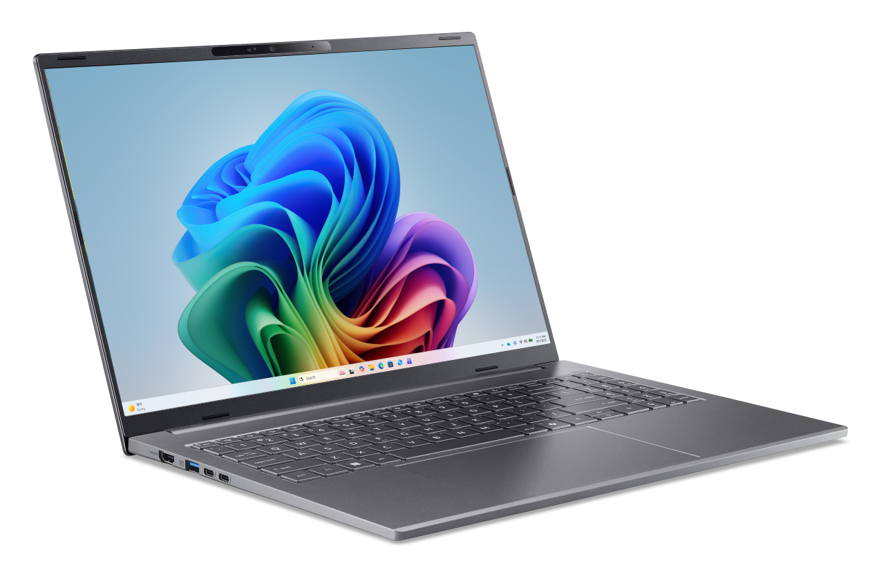 Szary laptop z kolorową tapetą na otwartym ekranie.