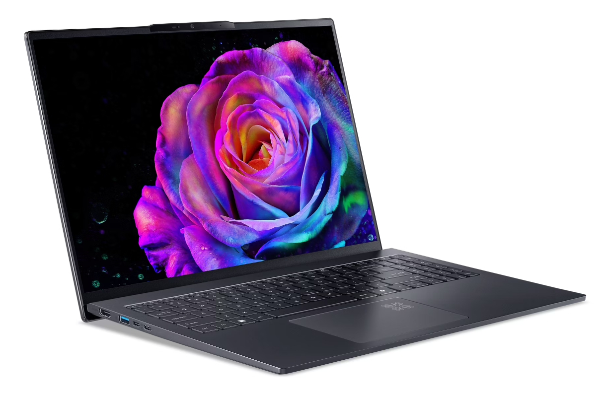 Ciemny laptop wyświetla żywą, kolorową różę na ekranie na czarnym tle.