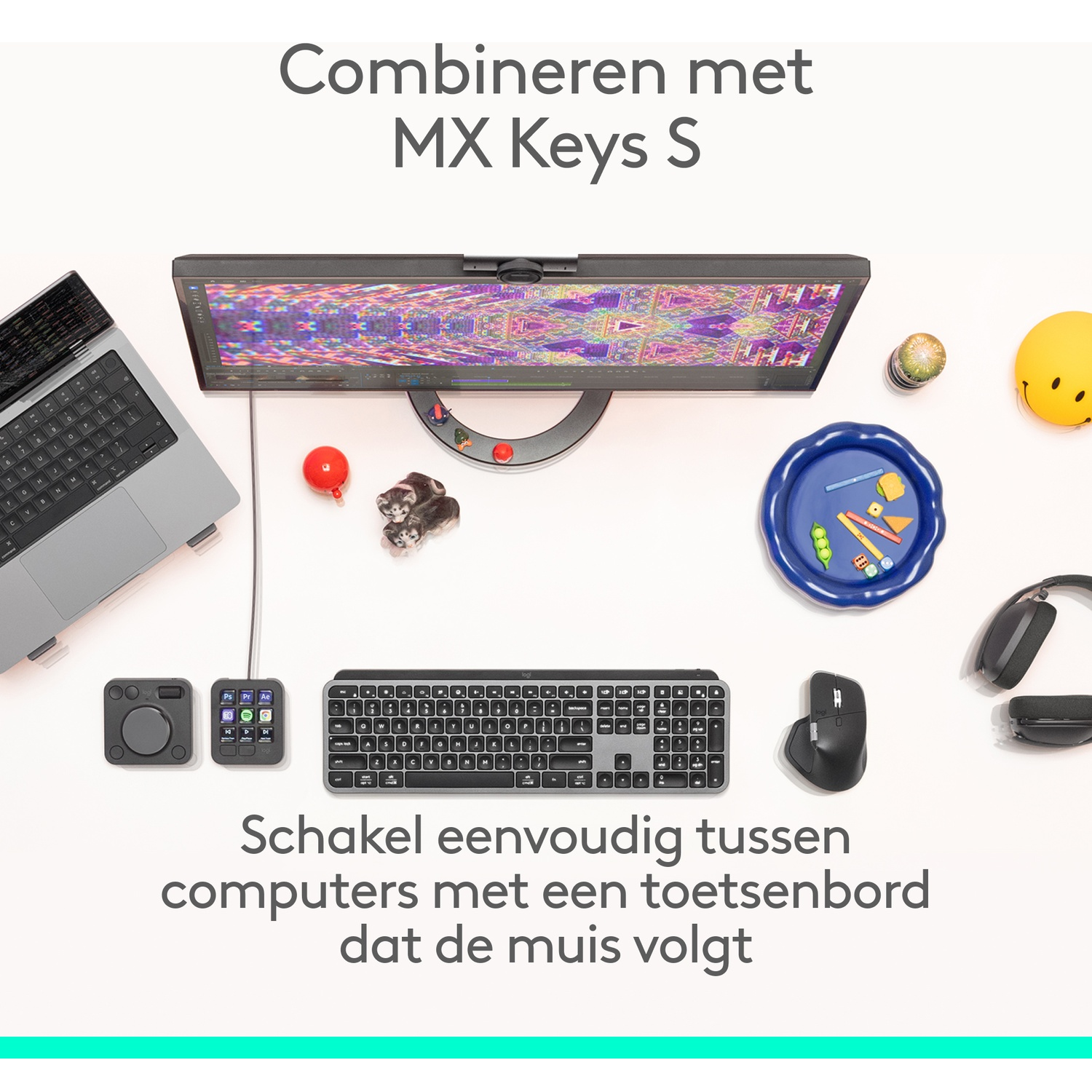 A laptop, monitor, keyboard, mouse, headphones, and toys on a white table.
