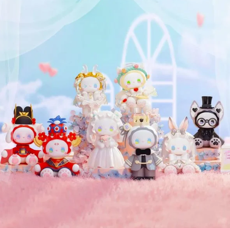 Eine Gruppe von niedlichen Vinylfiguren in verschiedenen Kostümen vor einem blauen Himmel mit Bögen.