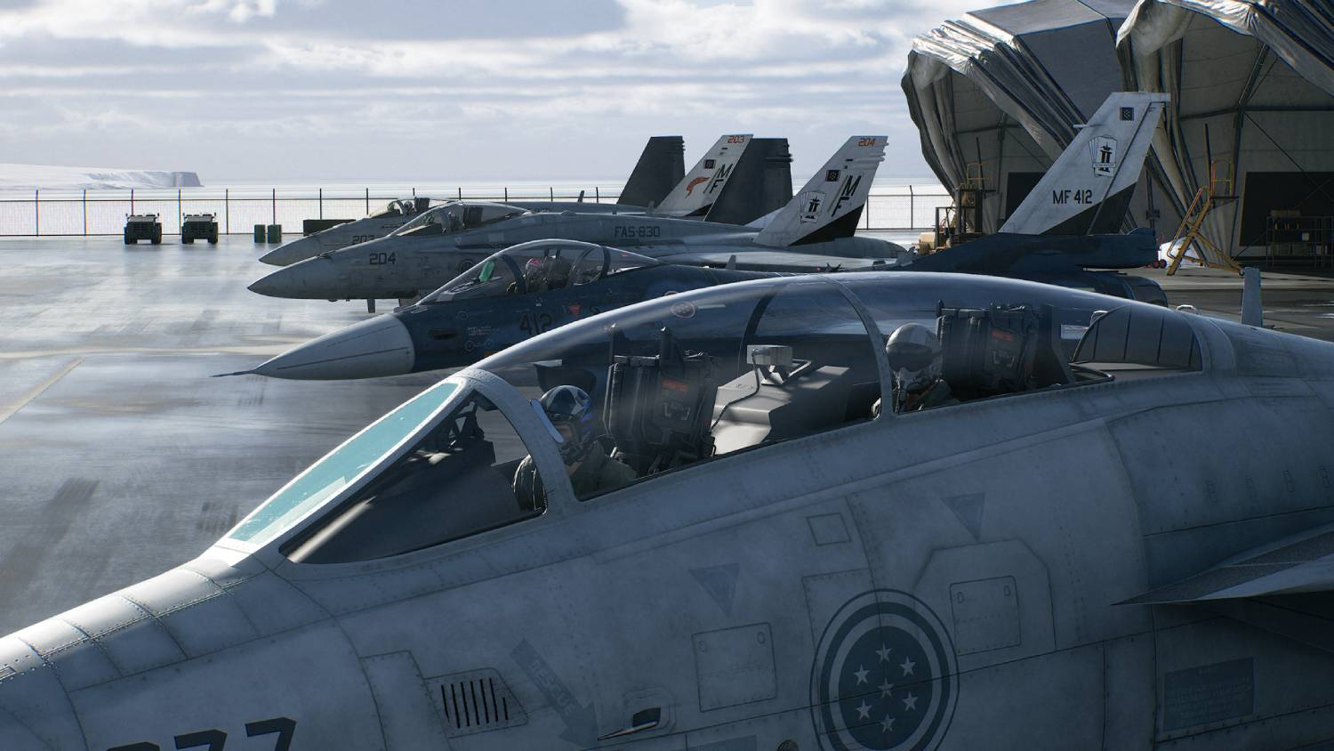 Cubierta de portaaviones con cuatro cazas, pilotos en cabinas, montañas al fondo.