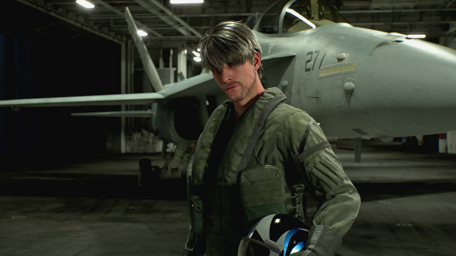Un hombre con uniforme de piloto está frente a un avión en un hangar.