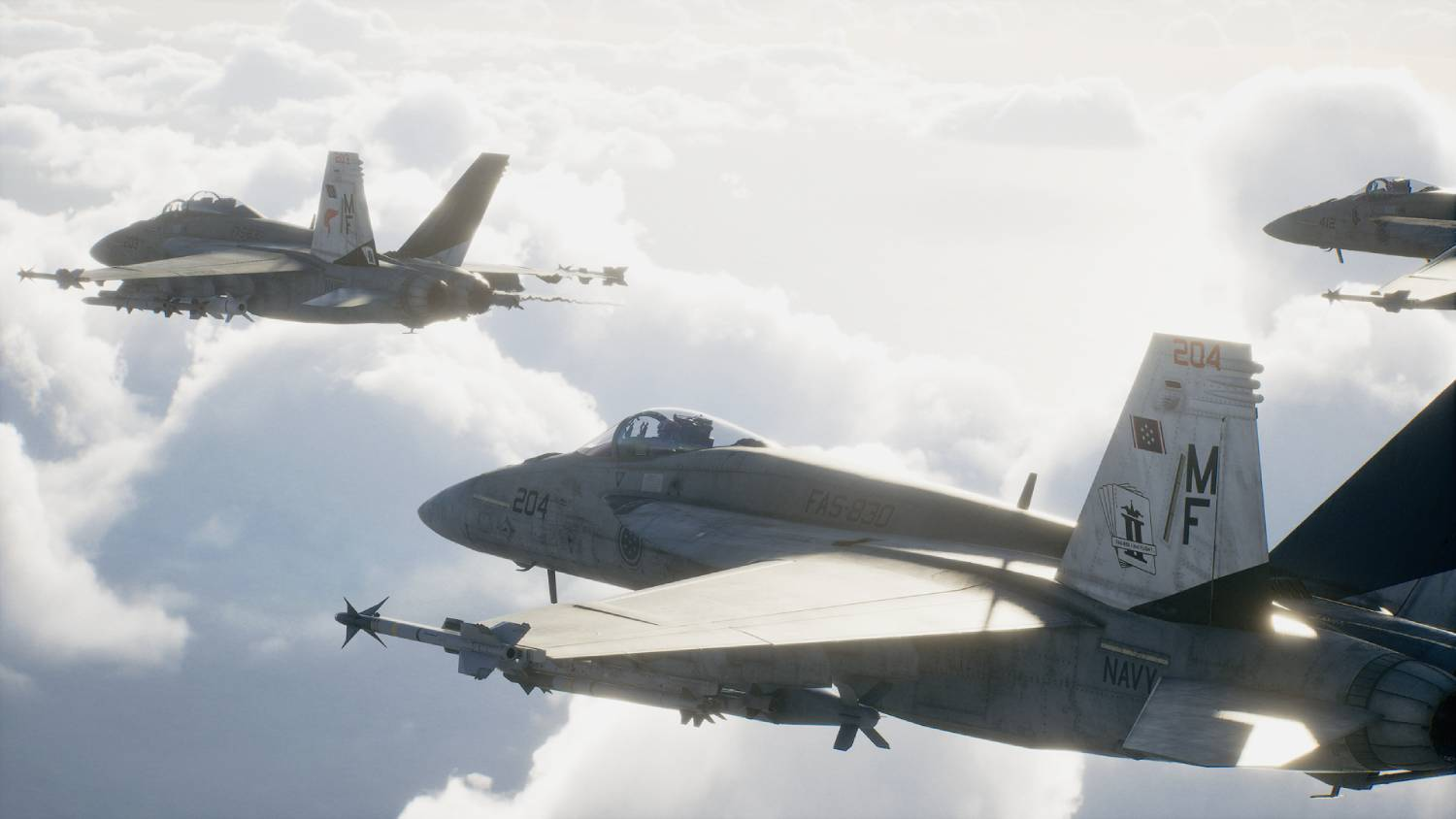 Tres aviones F-18 de la Marina vuelan entre nubes, el sol brilla.