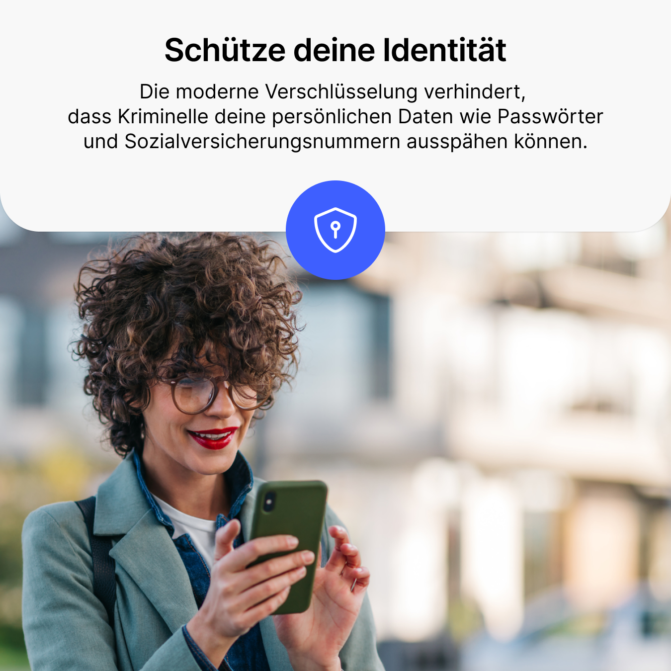 Femme aux cheveux bouclés regarde son smartphone, une icône de bouclier est visible.