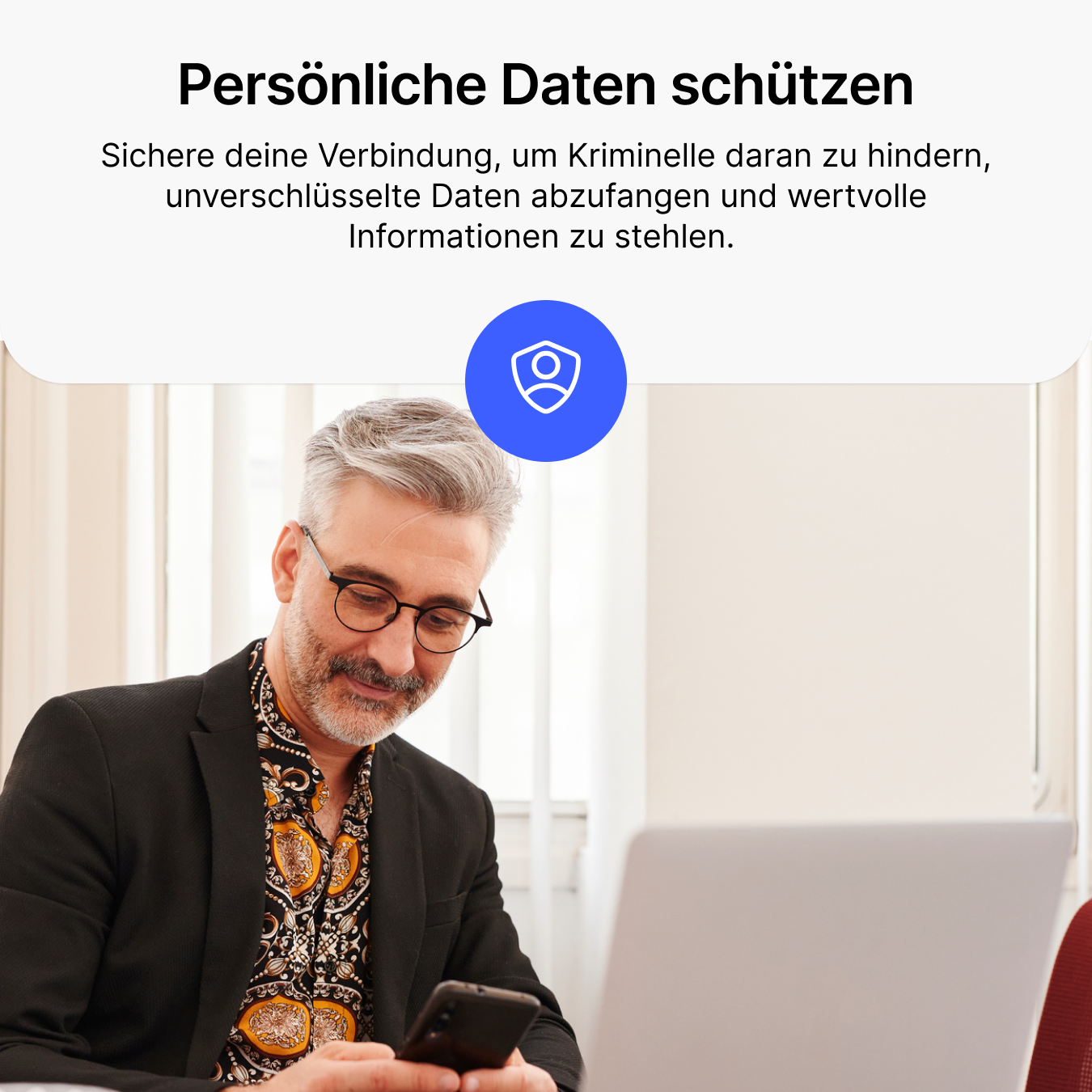 Homme avec lunettes et chemise regarde son téléphone, à côté d'un ordinateur portable et d'une icône de sécurité.